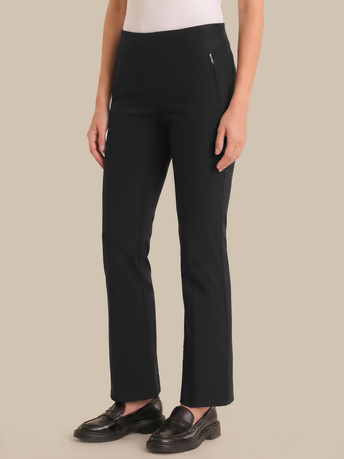 Person wearing black pants on a beige background