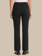Person wearing black pants on a beige background