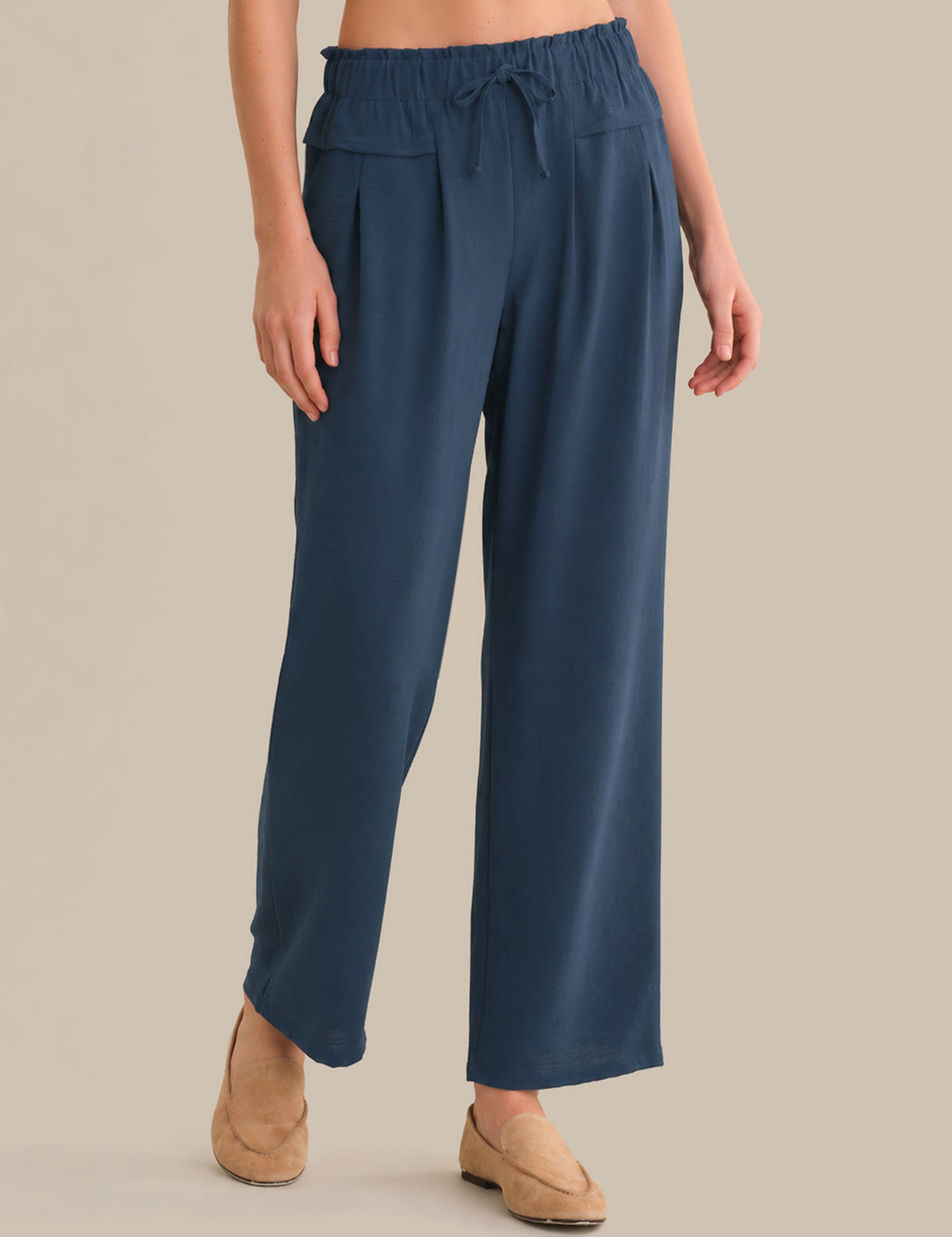 Person wearing blue pants on a beige background