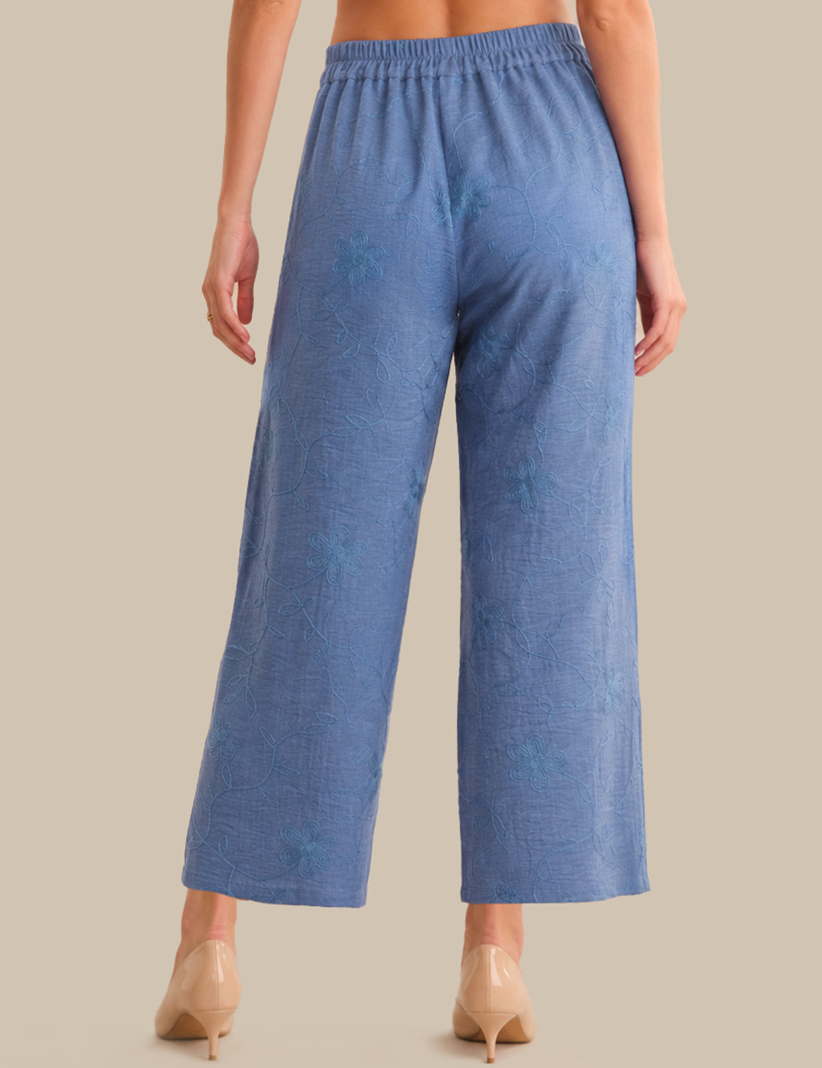 Blue textured pants worn by a person on a beige background