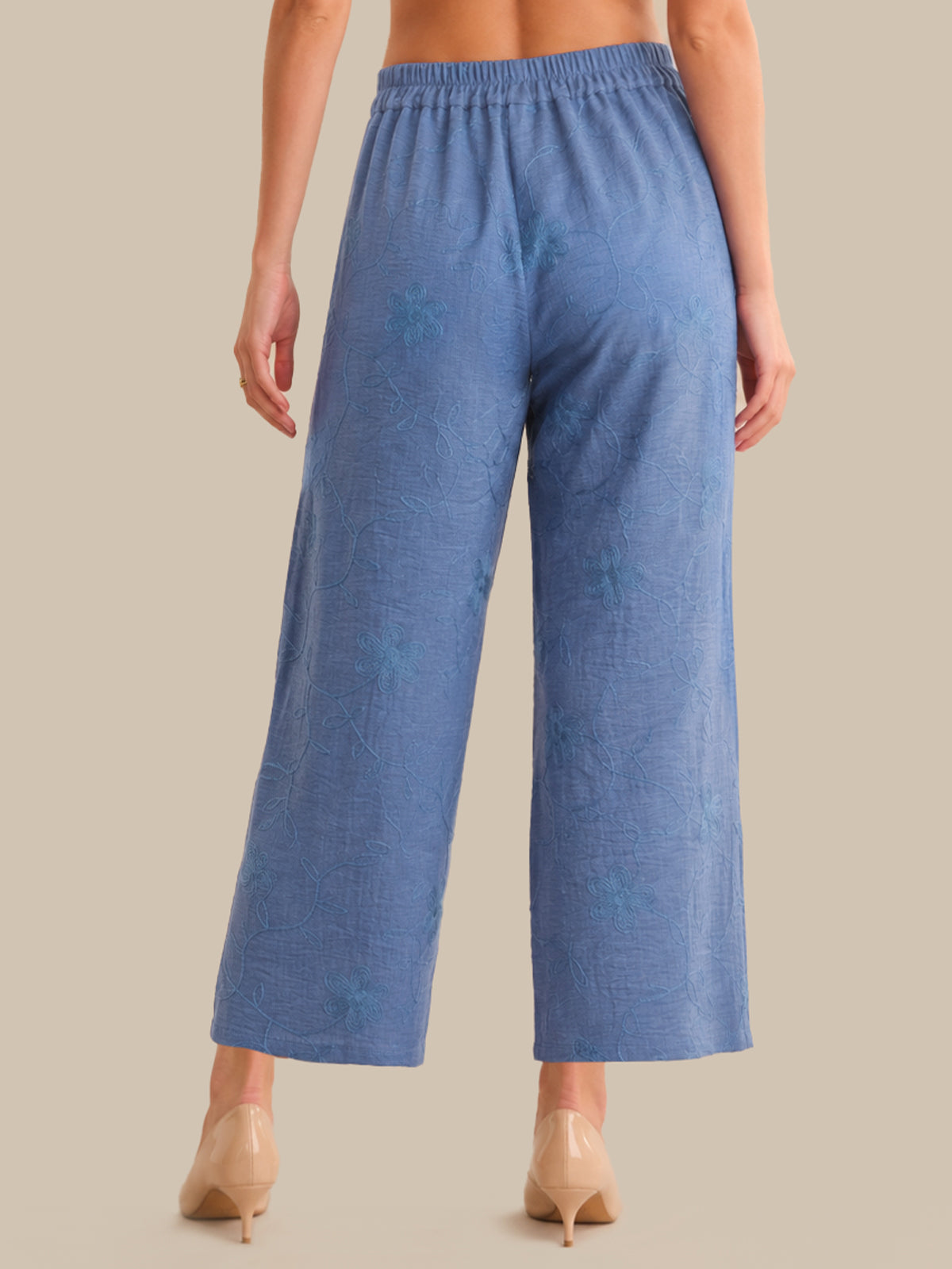 Blue textured pants worn by a person on a beige background