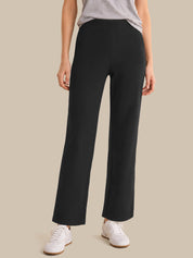 Person wearing black wide-leg pants on a beige background