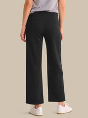 Person wearing black wide-leg pants on a beige background