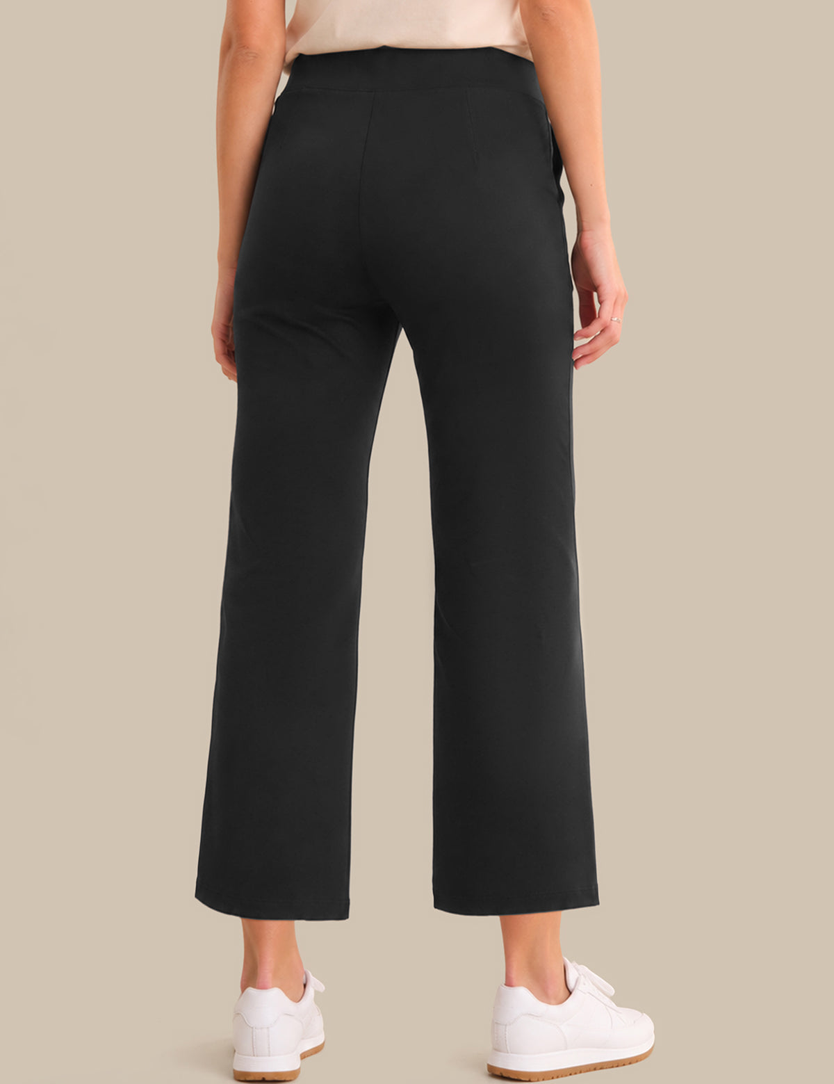 Person wearing black pants on a beige background