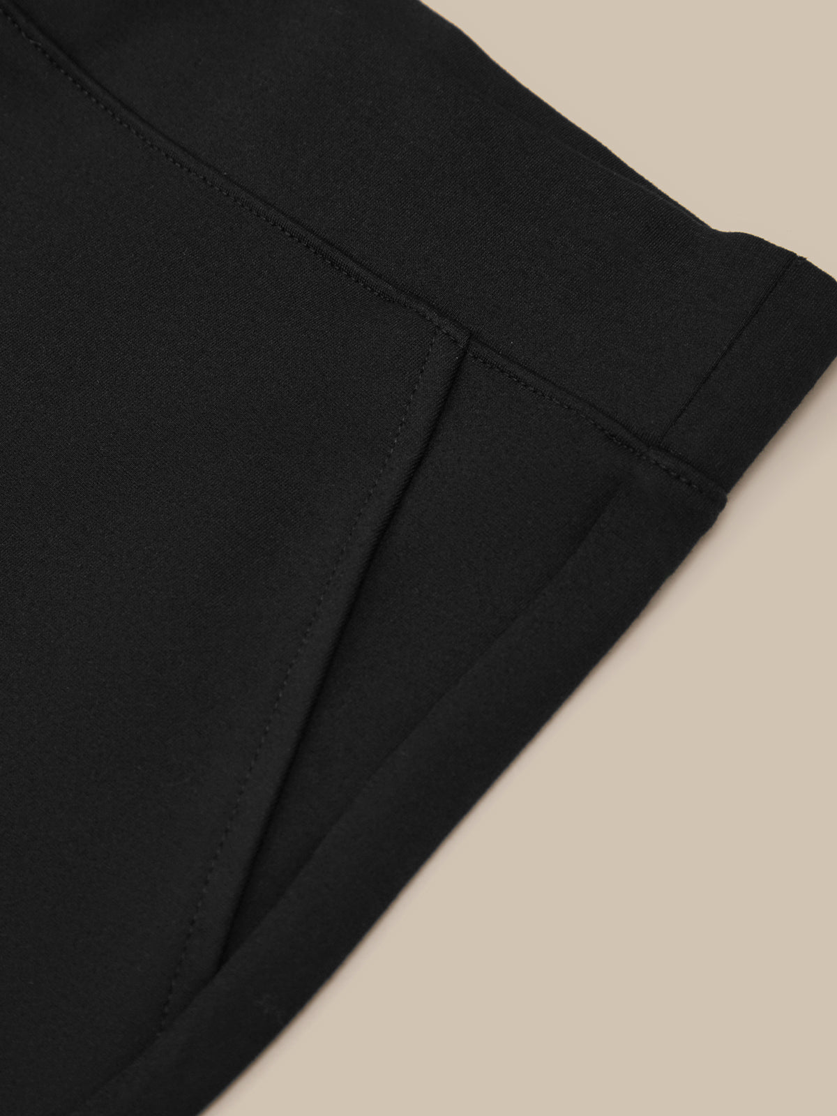 Close-up of black pants on a beige background
