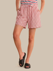 Person wearing red and white striped shorts on a beige background
