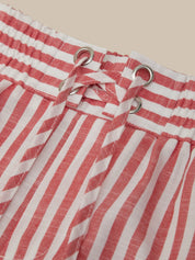 Red and white striped pants with drawstring on a beige background