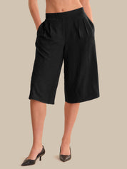 Black wide-leg pants worn by a person on a beige background