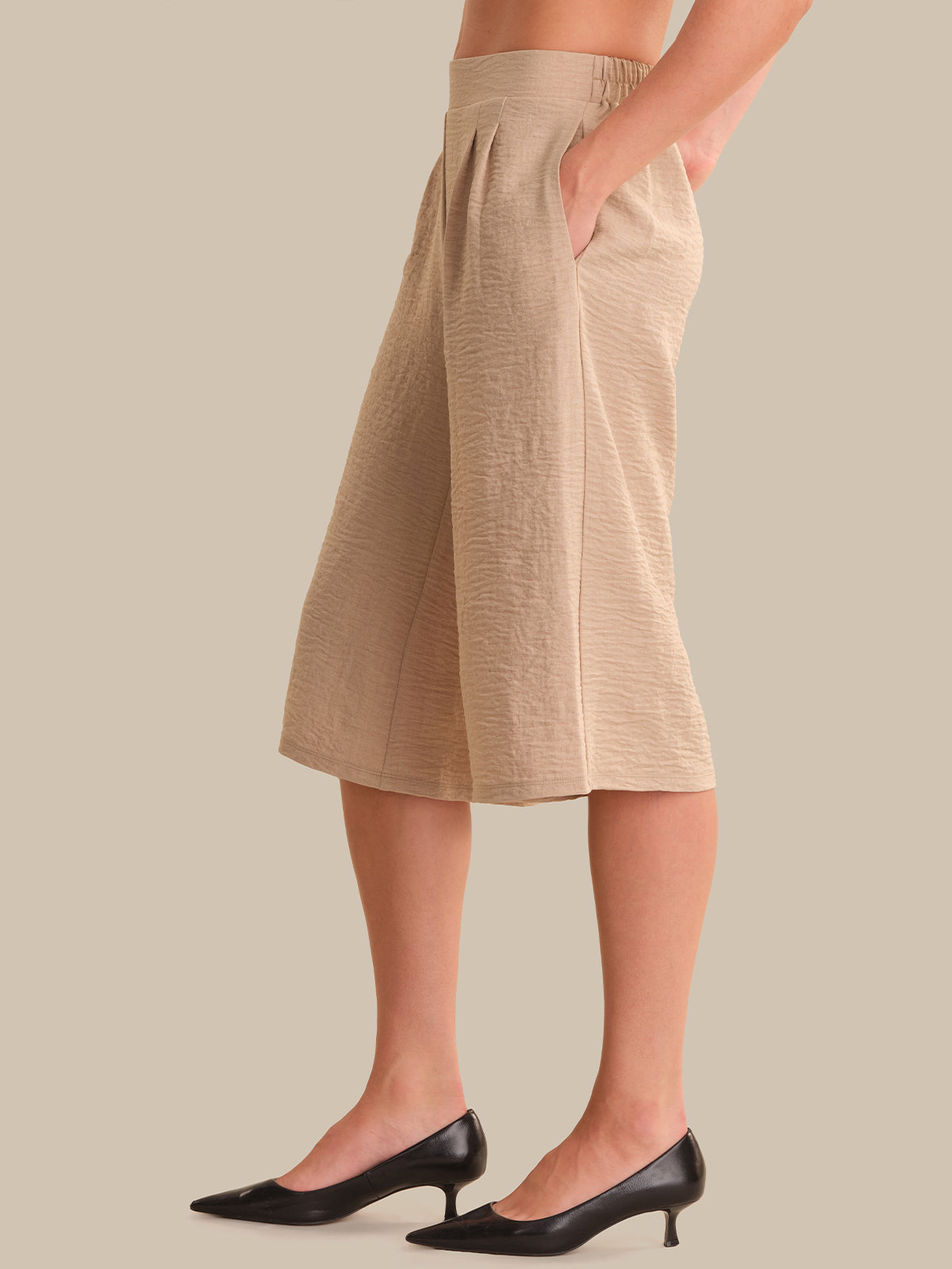 Beige skirt worn by a person on a beige background