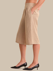 Beige skirt worn by a person on a beige background