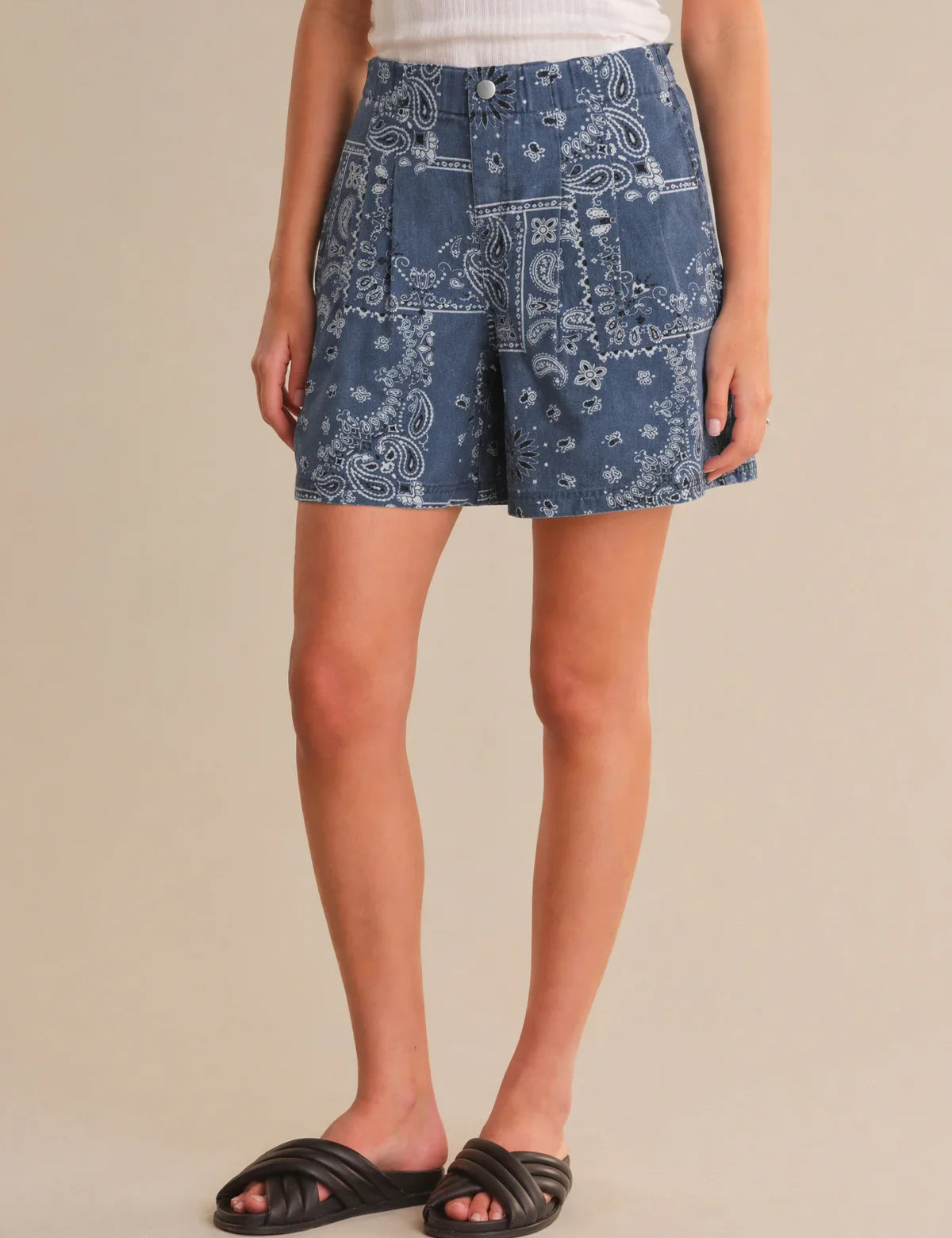 Person wearing blue patterned shorts on a beige background