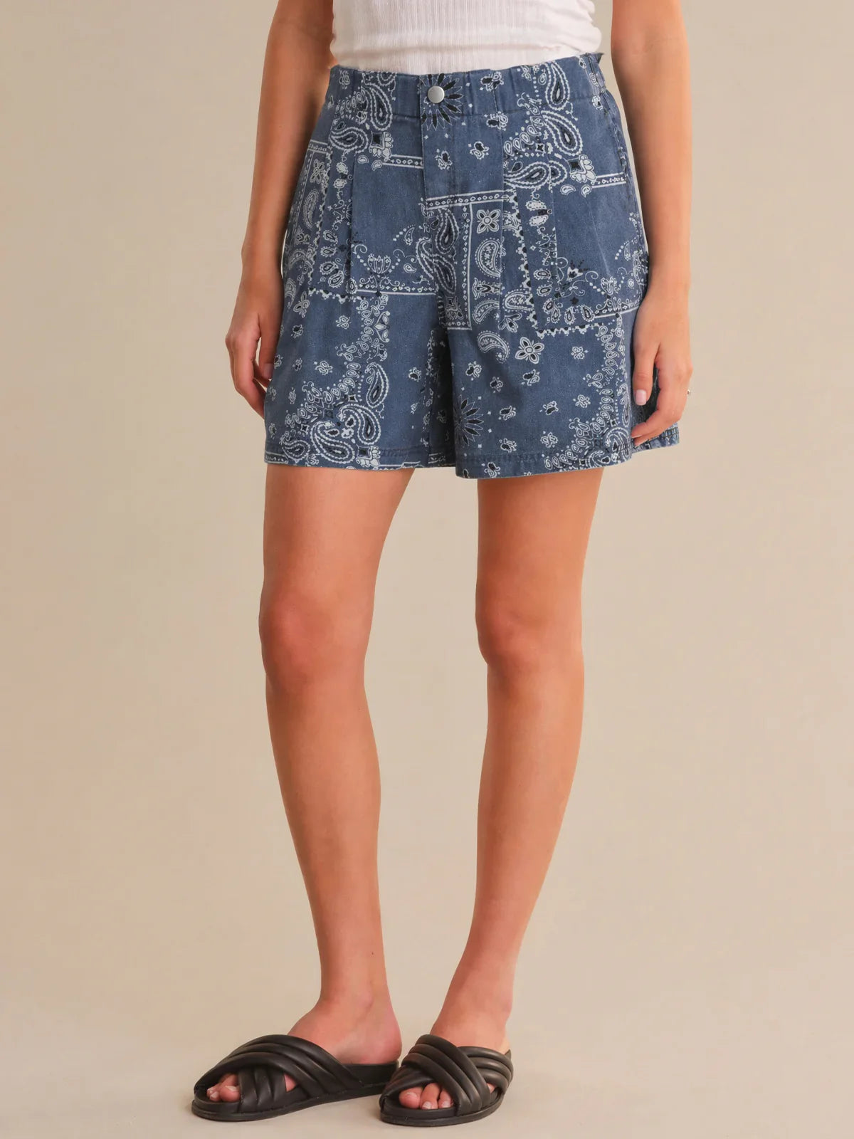 Person wearing blue patterned shorts on a beige background