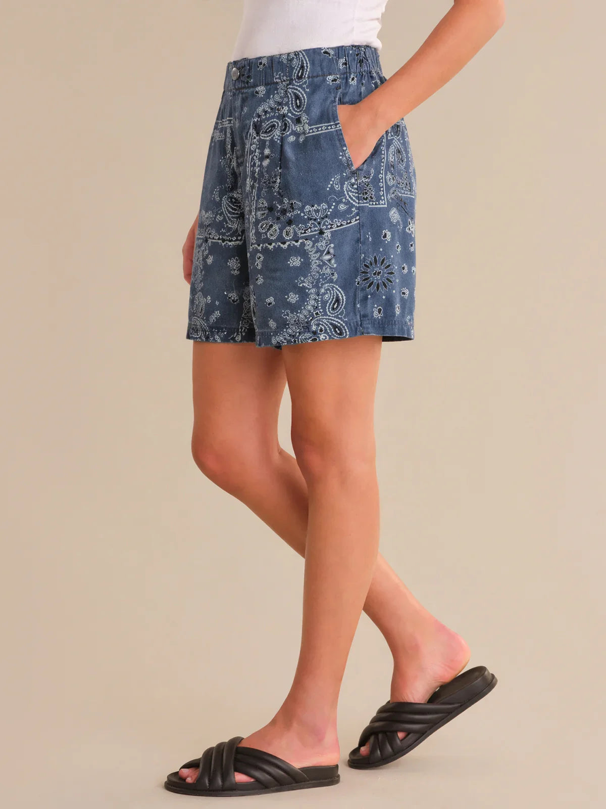 Person wearing a blue patterned skirt on a beige background