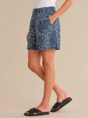 Person wearing a blue patterned skirt on a beige background