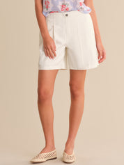Person wearing white shorts on a beige background
