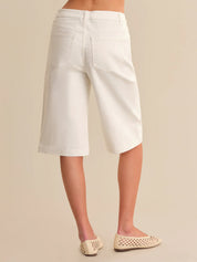 White shorts worn by a person on a beige background