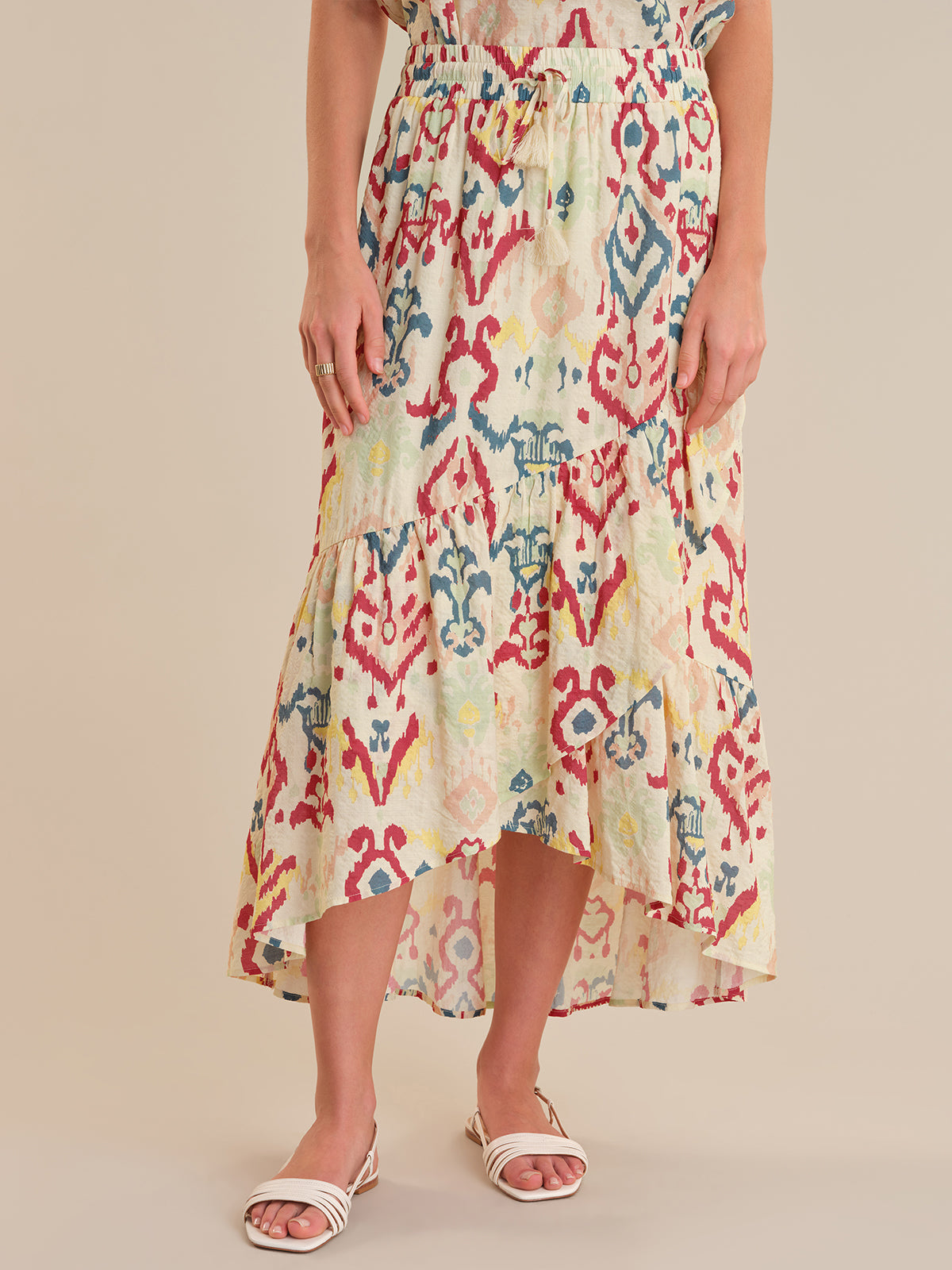 Woman wearing a colorful patterned dress on a beige background