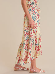 Person wearing a colorful patterned dress on a beige background