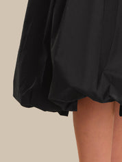 Black shorts being worn on a beige background