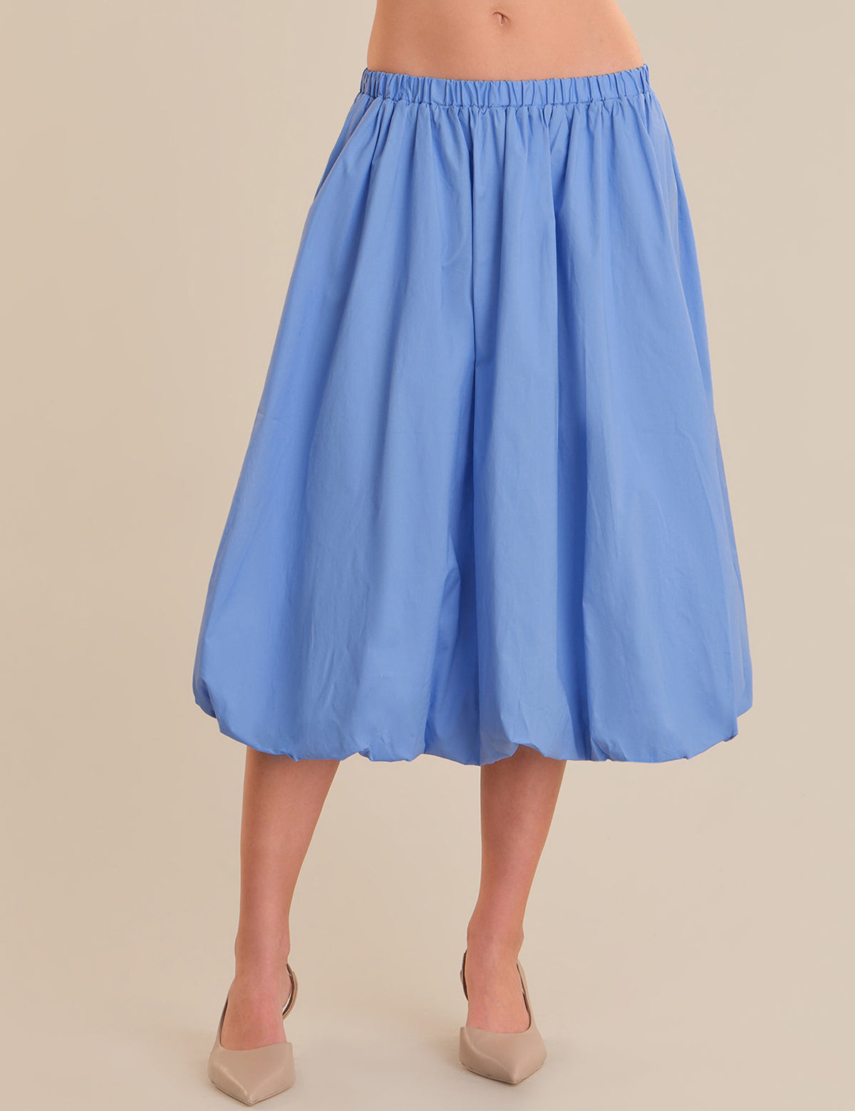 Light blue skirt worn by a person on a beige background
