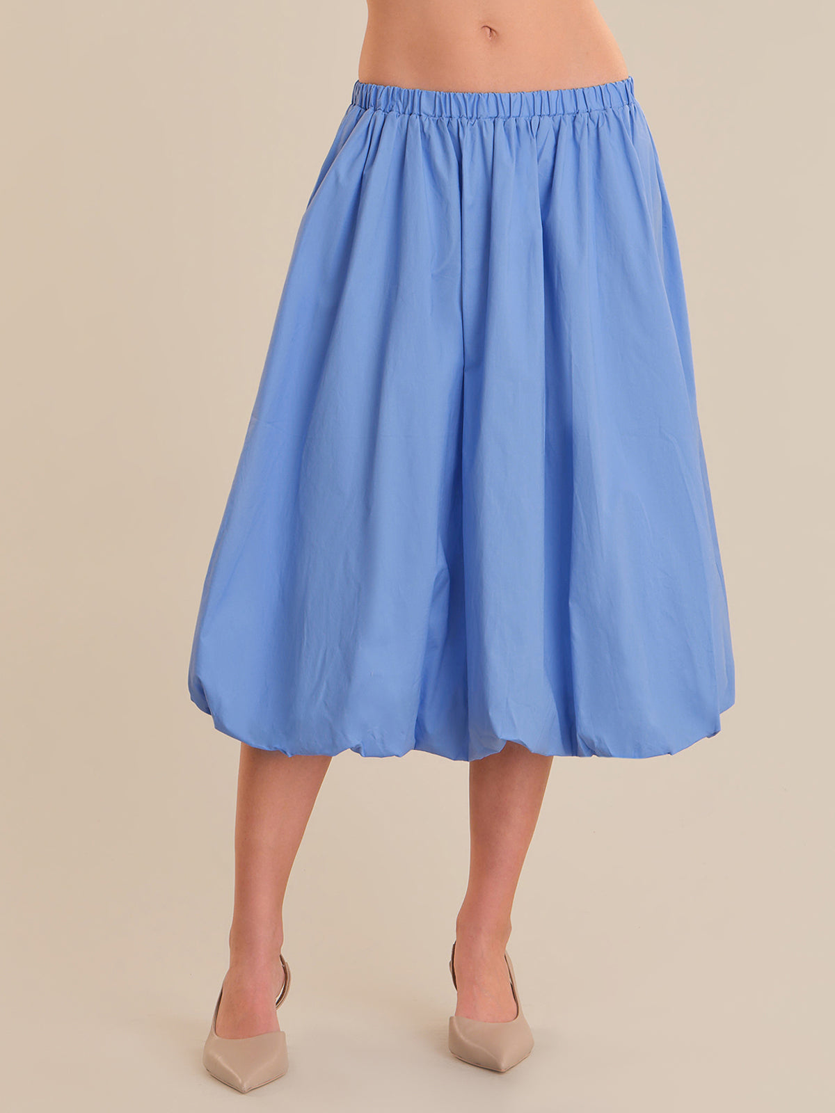Light blue skirt worn by a person on a beige background