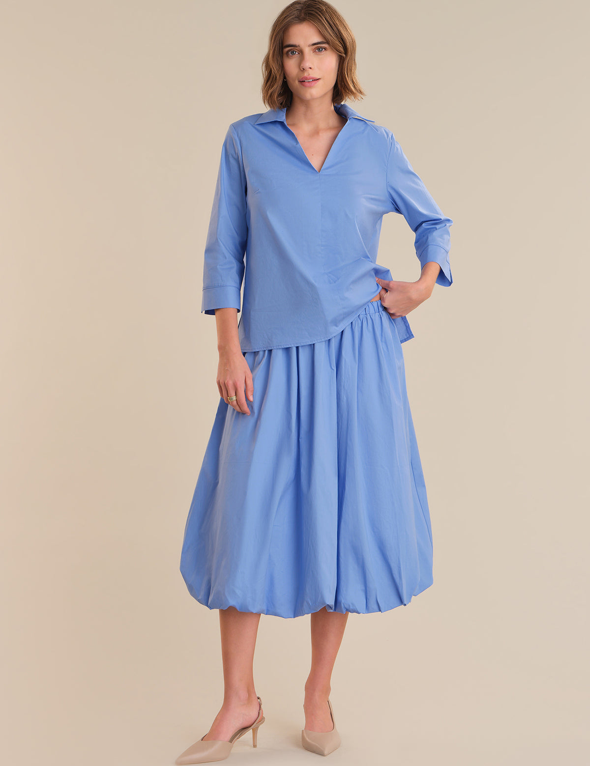 Woman wearing a blue dress with a plain background