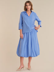 Woman wearing a blue dress with a plain background