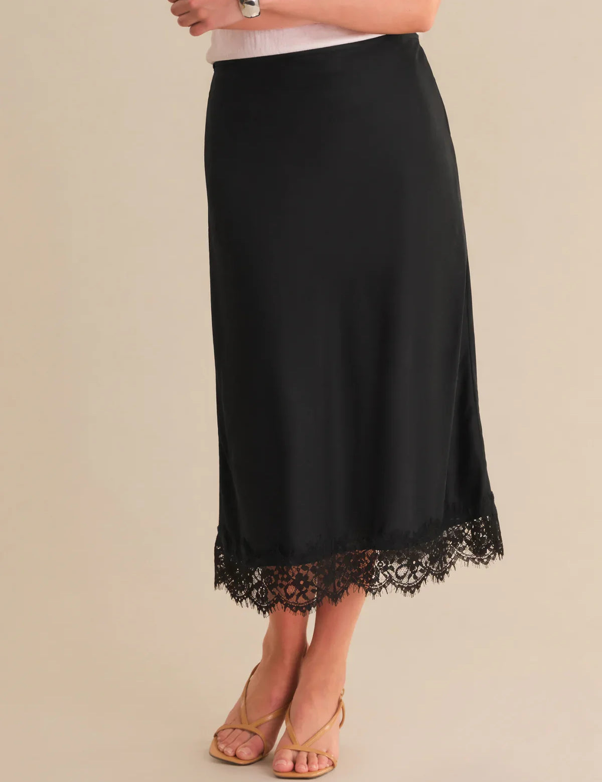 Black skirt with lace hem on a beige background