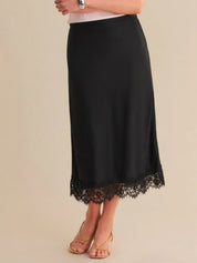 Black skirt with lace hem on a beige background