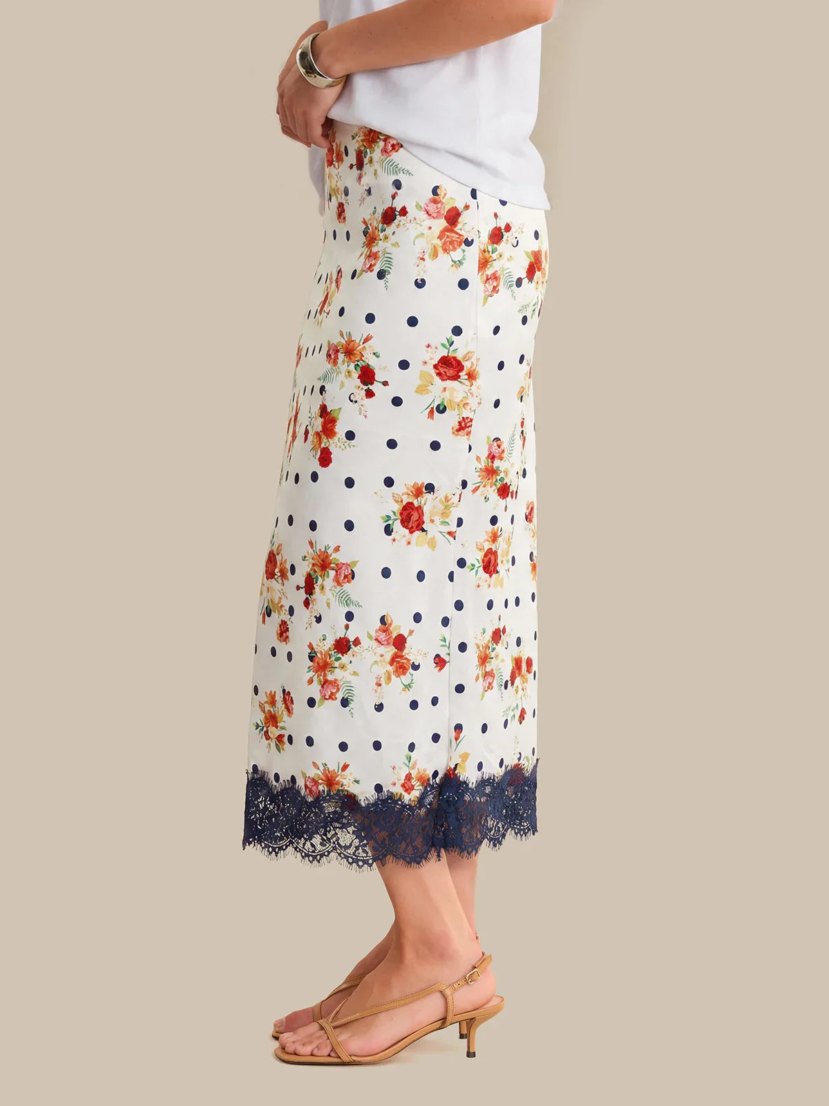 Floral polka dot skirt with lace trim worn by a person on a neutral background