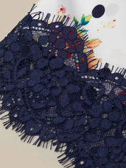 Navy blue lace fabric with colorful floral design in the background