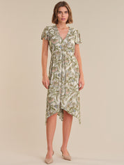 Woman wearing a green floral dress on a beige background