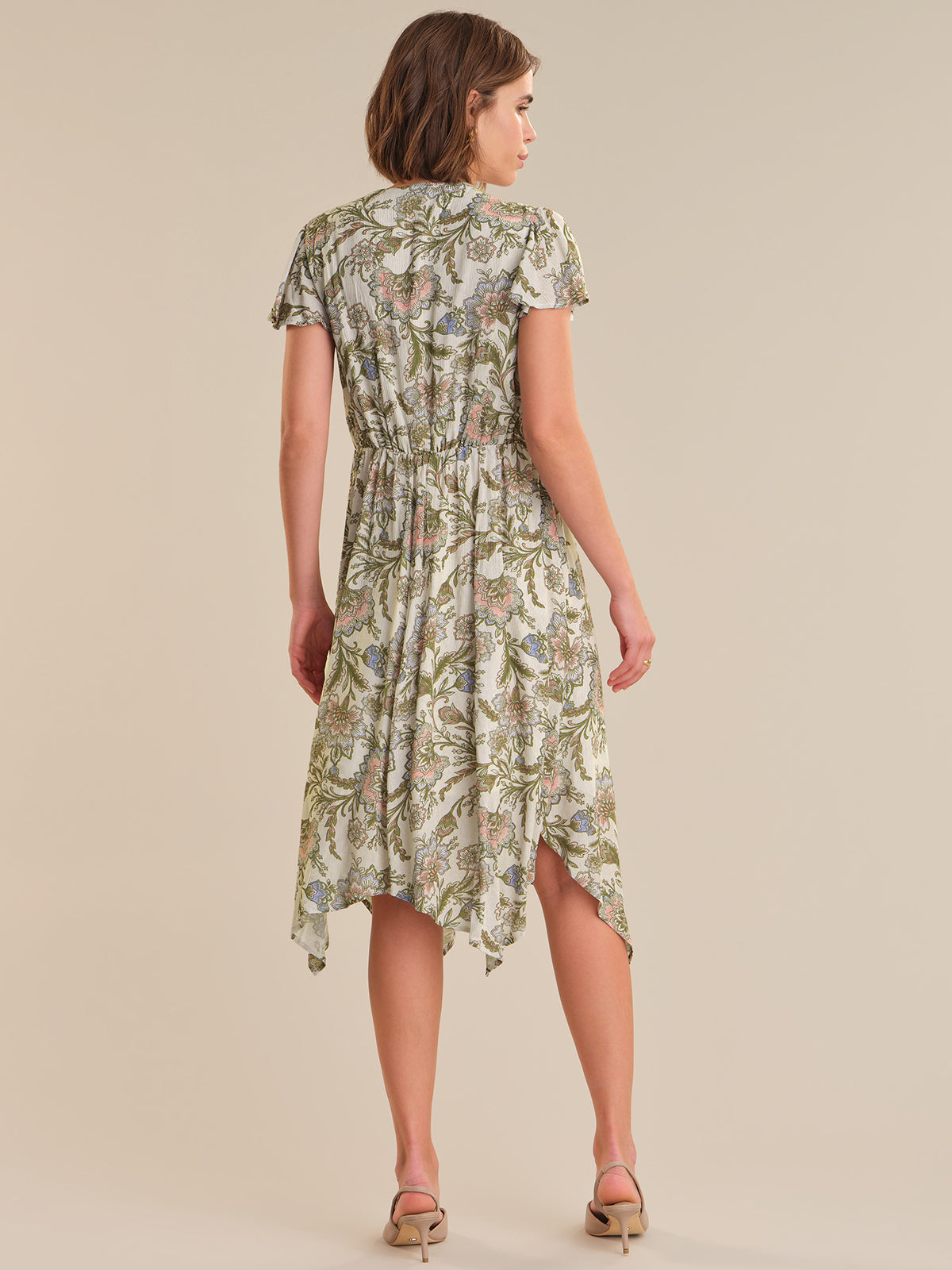 Woman wearing a floral dress on a beige background