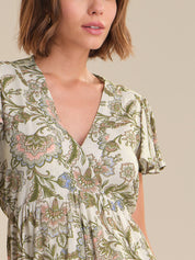 Woman wearing a floral dress with a neutral background