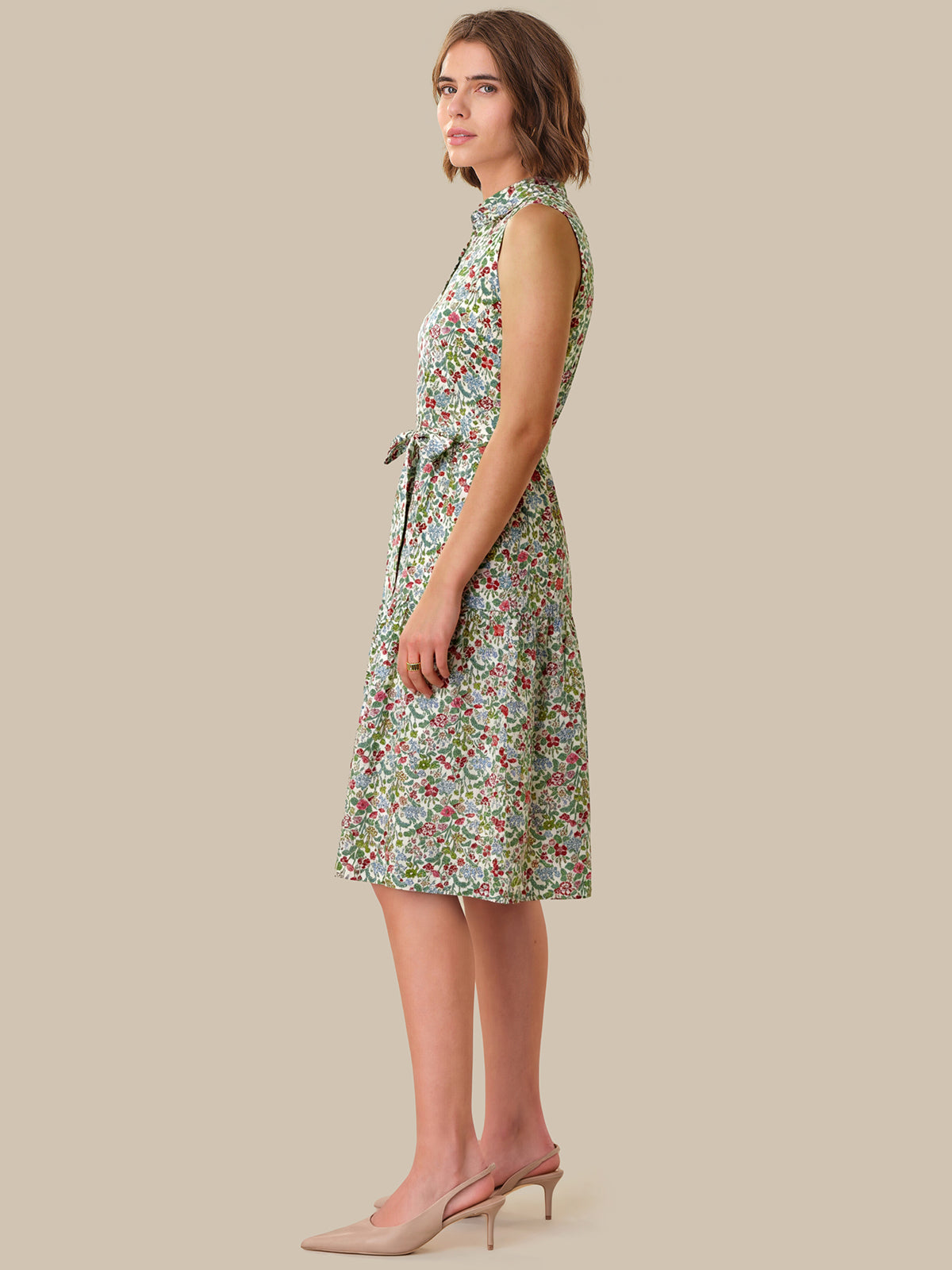 Woman wearing a floral dress against a beige background