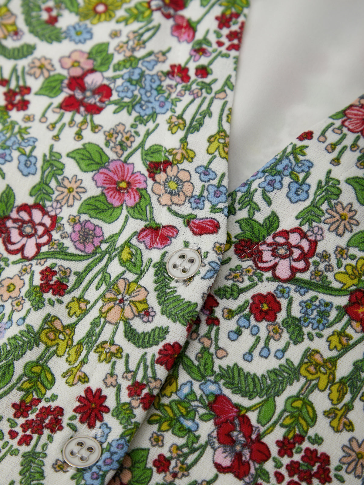 Close-up of a floral-patterned fabric with a button detail.