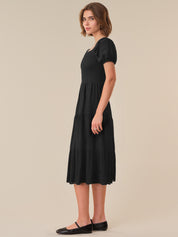 Woman wearing a black dress against a beige background