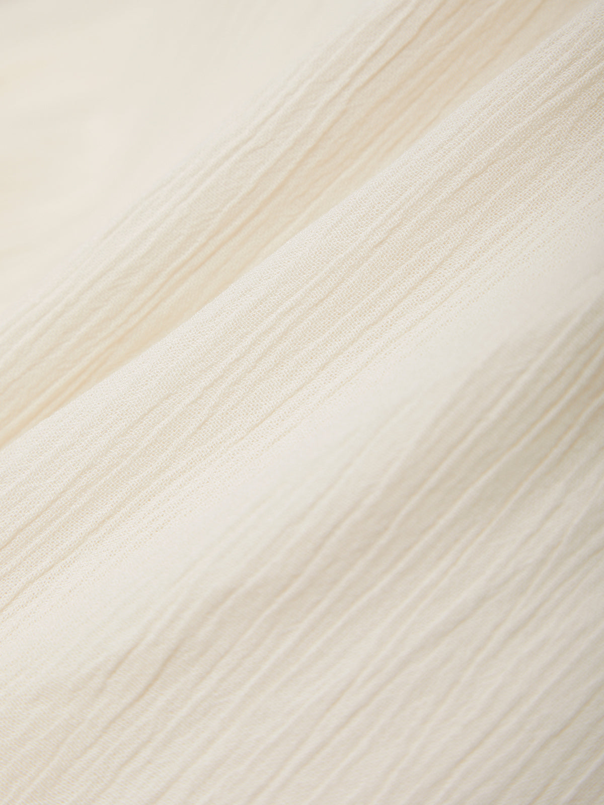 Close-up of a textured fabric with diagonal stripes in beige and white.