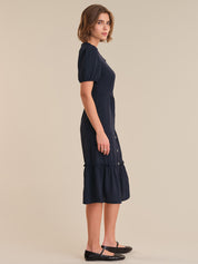 Woman wearing a navy dress on a beige background