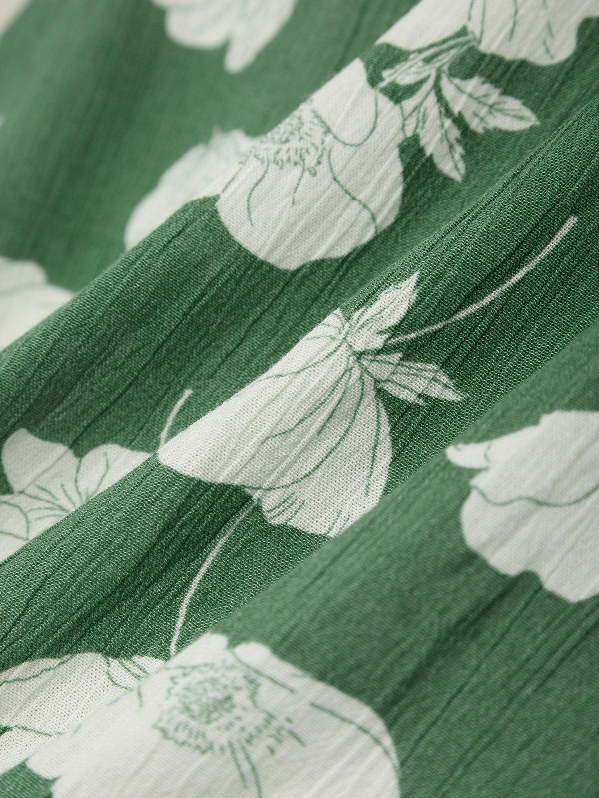 Close-up of green fabric with white floral pattern