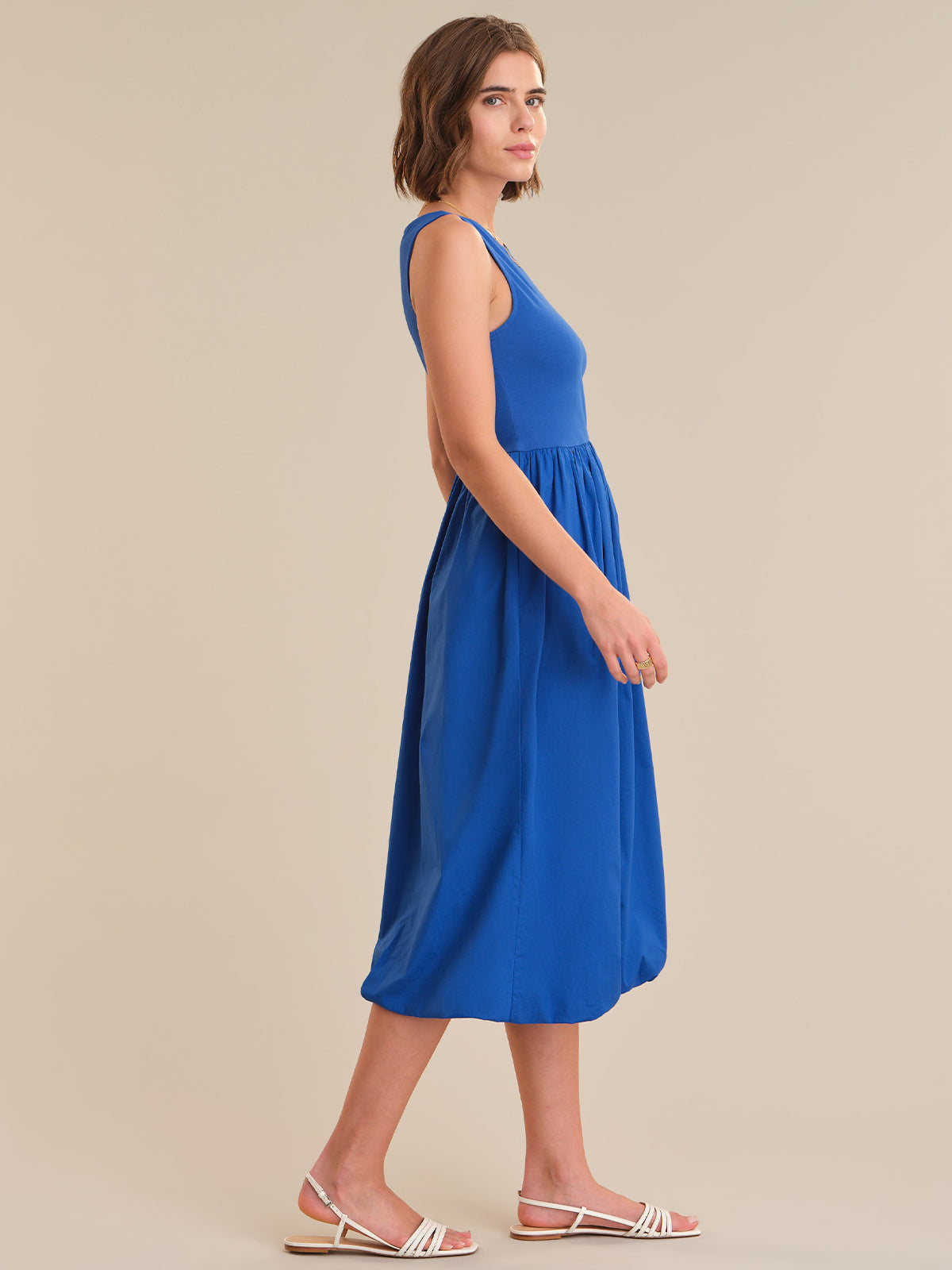 Woman wearing a blue dress against a beige background