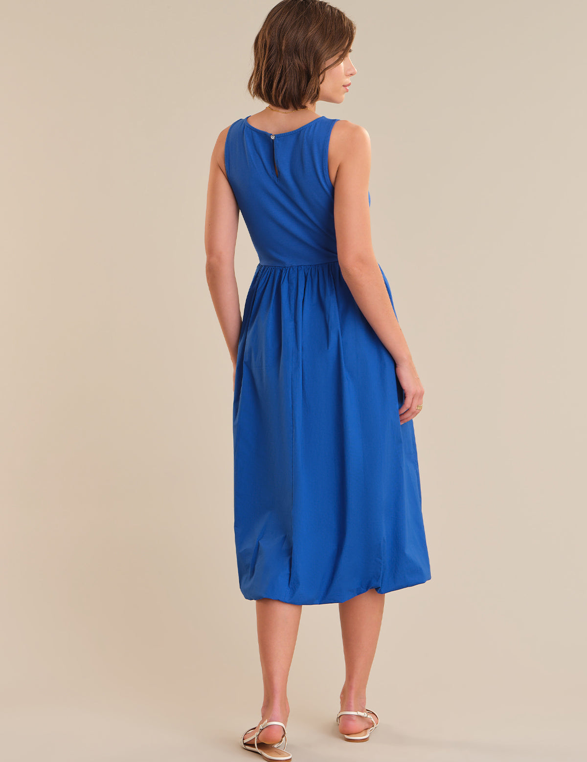 Woman wearing a blue dress on a beige background