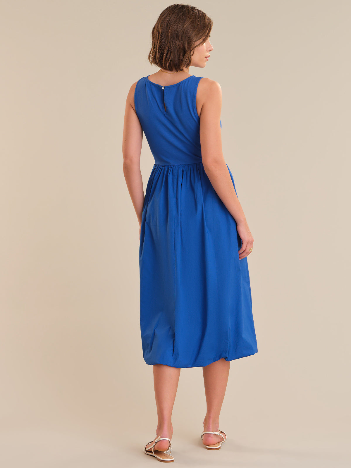 Woman wearing a blue dress on a beige background