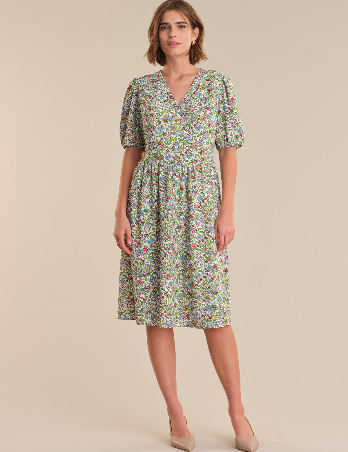 Woman wearing a floral dress on a beige background