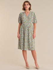 Woman wearing a floral dress on a beige background