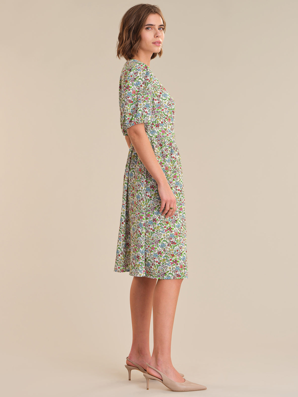 Woman wearing a floral dress on a beige background