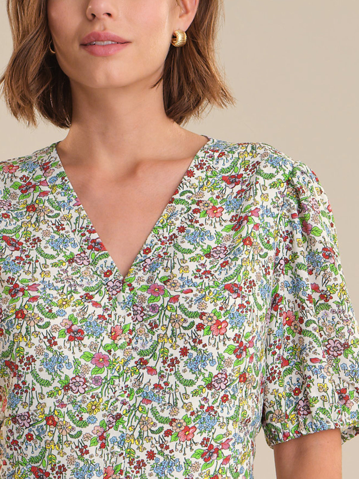 Woman wearing a floral patterned dress with a neutral background