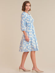 Woman wearing a blue floral dress on a beige background