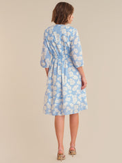 Woman wearing a blue floral dress on a beige background