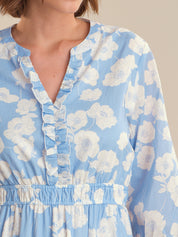 Blue floral dress with ruffled neckline on a neutral background
